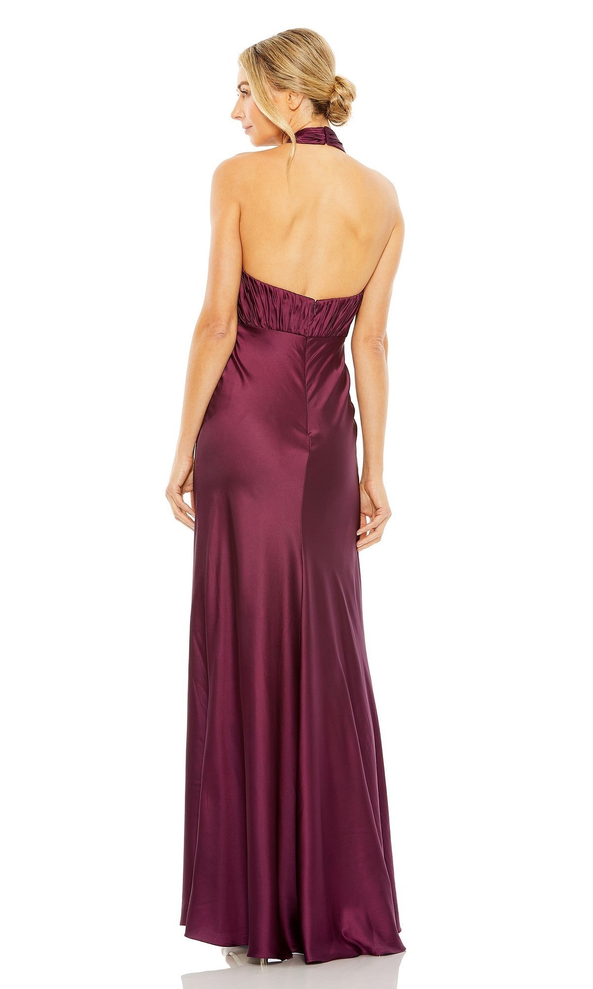 A woman is shown from the back, her hair styled in a low bun, wearing the Mac Duggal 55995 long formal dress— a floor-length satin gown in deep burgundy with a sleeveless, halter neckline.